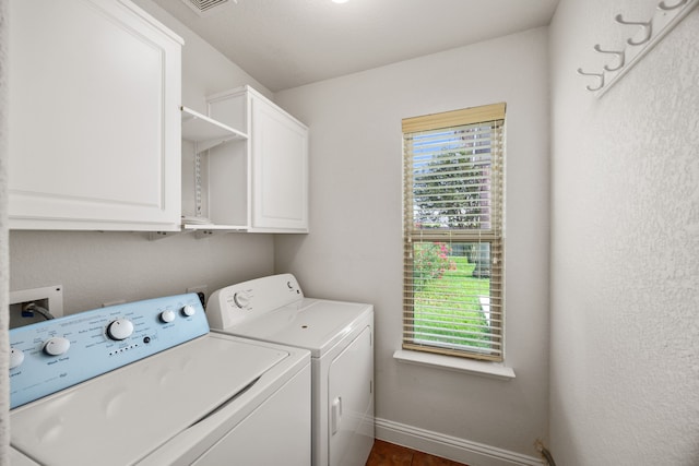 laundry area with cabinet space, separate washer and dryer, and baseboards