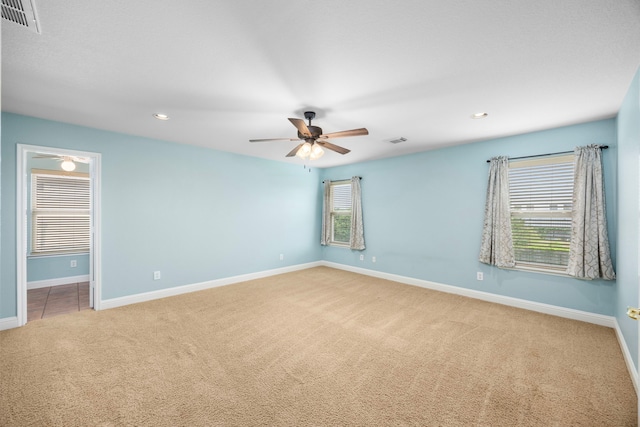carpeted spare room featuring a ceiling fan, baseboards, visible vents, and recessed lighting
