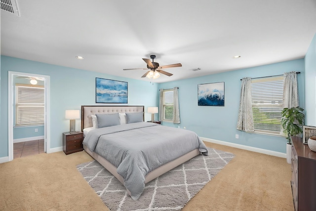 bedroom featuring baseboards, light carpet, and visible vents