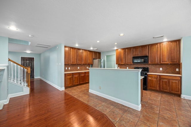 kitchen with decorative backsplash, brown cabinets, light countertops, black appliances, and recessed lighting