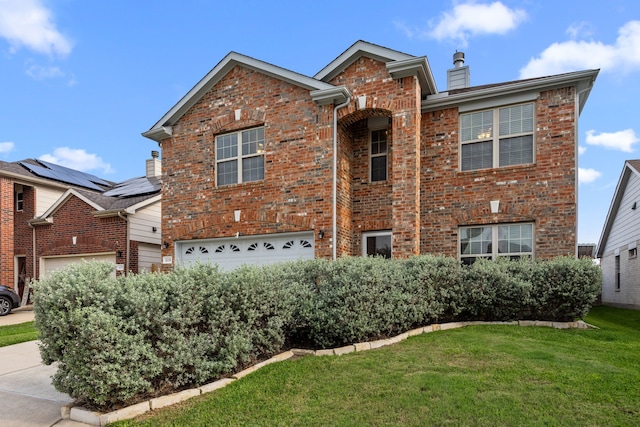 traditional-style home featuring a chimney, a garage, brick siding, a front lawn, and concrete driveway
