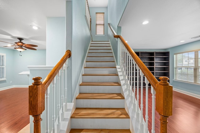 staircase featuring a ceiling fan, baseboards, recessed lighting, wood finished floors, and visible vents