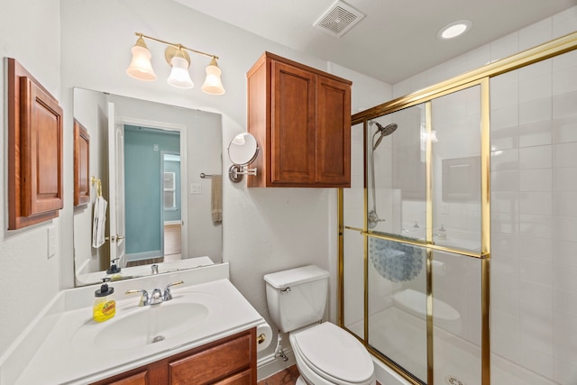 bathroom featuring vanity, a shower stall, toilet, and visible vents