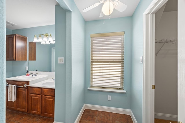 bathroom featuring double vanity, a ceiling fan, visible vents, a sink, and baseboards
