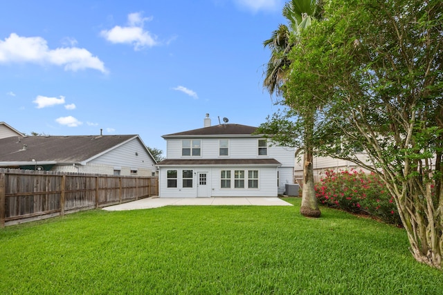 back of house featuring a chimney, a lawn, central AC unit, a fenced backyard, and a patio