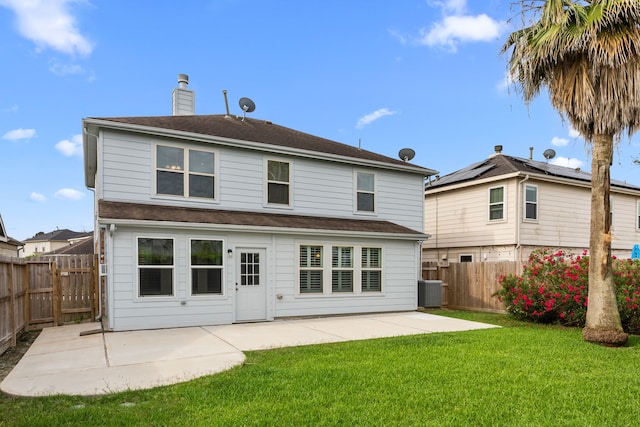 back of house with central AC, a patio, a fenced backyard, a chimney, and a yard
