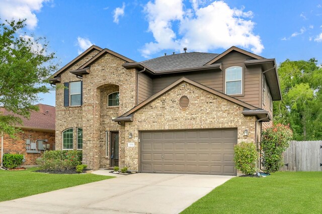 traditional-style house featuring brick siding, a front lawn, fence, and concrete driveway