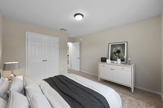 bedroom featuring baseboards, light carpet, a closet, and visible vents