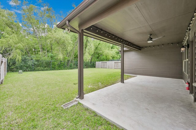 view of yard featuring a fenced backyard, ceiling fan, and a patio area