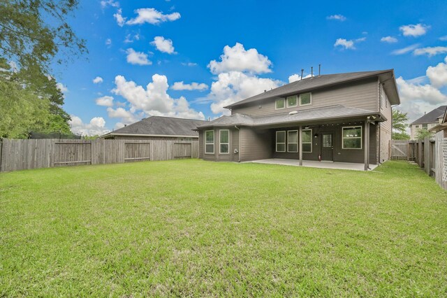 rear view of property with a patio, a fenced backyard, and a lawn