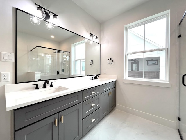 bathroom featuring a sink, baseboards, a shower stall, and double vanity