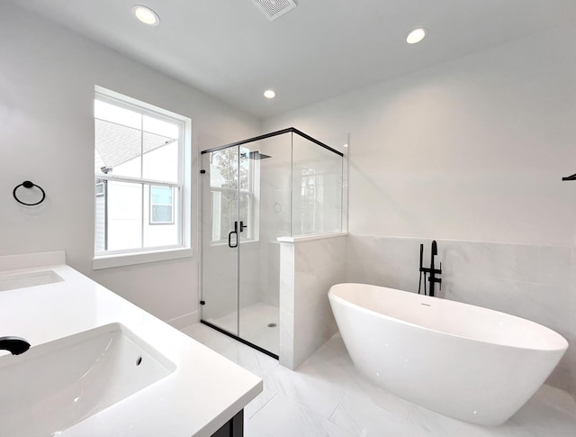 full bath with recessed lighting, a sink, a freestanding bath, and a stall shower