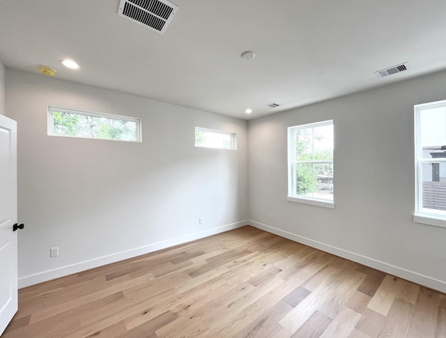 empty room with plenty of natural light, light wood-style flooring, and visible vents