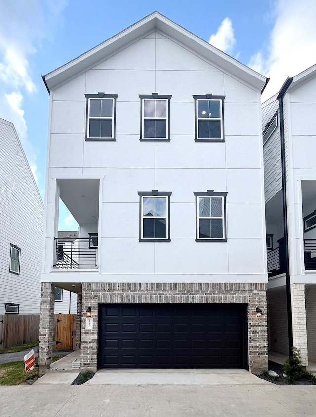 view of front facade with a garage, fence, concrete driveway, and brick siding