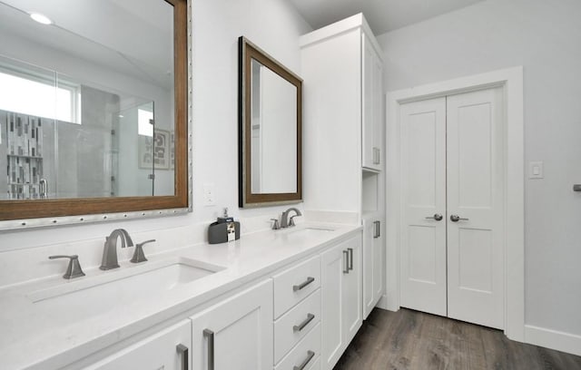 22814 Camino St, Galveston, TX 77554 - full bath featuring a sink, double vanity, a shower stall, and wood finished floors