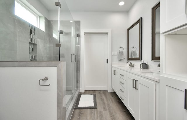 22814 Camino St, Galveston, TX 77554 - full bathroom featuring a sink, double vanity, recessed lighting, wood finished floors, and a stall shower