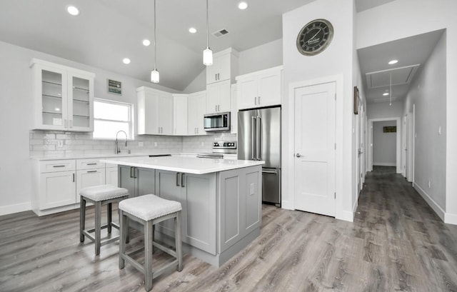 22814 Camino St, Galveston, TX 77554 - kitchen featuring visible vents, lofted ceiling, a center island, tasteful backsplash, and stainless steel appliances