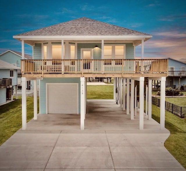 22814 Camino St, Galveston, TX 77554 - exterior space with concrete driveway, a lawn, an attached garage, and roof with shingles