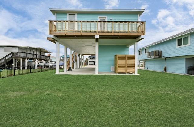 22814 Camino St, Galveston, TX 77554 - rear view of property with fence, a carport, a deck, a lawn, and a patio