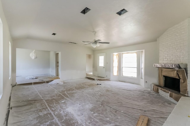 unfurnished living room with a ceiling fan, a brick fireplace, and vaulted ceiling