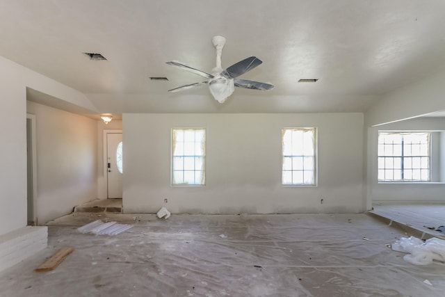 spare room with a ceiling fan, visible vents, and plenty of natural light