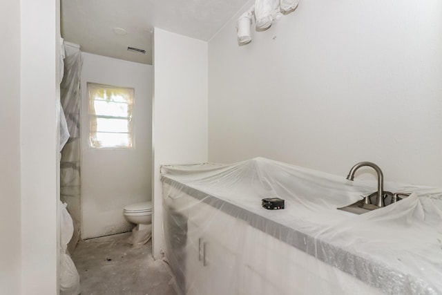 bathroom with toilet and visible vents