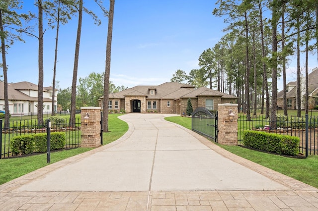 33026 Sawgrass Ct, Magnolia, TX 77354 - french country inspired facade with a front yard, fence private yard, a gate, brick siding, and curved driveway