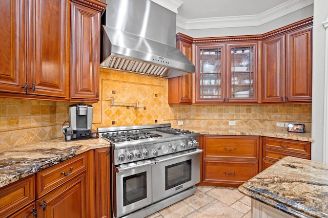 33026 Sawgrass Ct, Magnolia, TX 77354 - kitchen featuring wall chimney range hood, range with two ovens, light stone counters, and glass insert cabinets