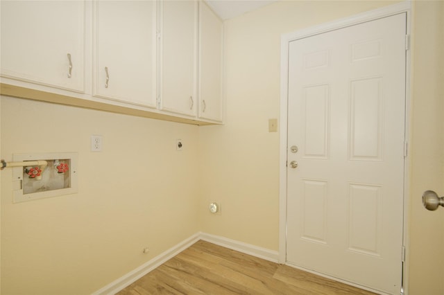 clothes washing area with cabinet space, hookup for a washing machine, baseboards, light wood-type flooring, and hookup for an electric dryer