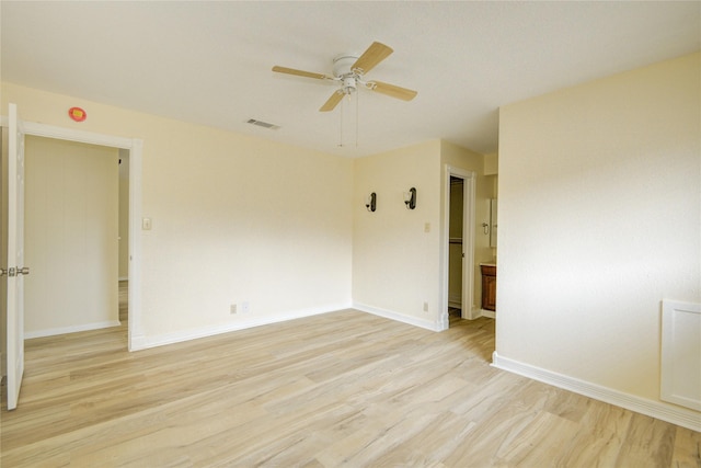 empty room featuring baseboards, a ceiling fan, light wood-type flooring, and visible vents
