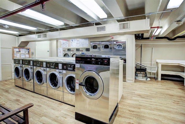 shared laundry area featuring separate washer and dryer, stacked washing maching and dryer, wood finished floors, and visible vents