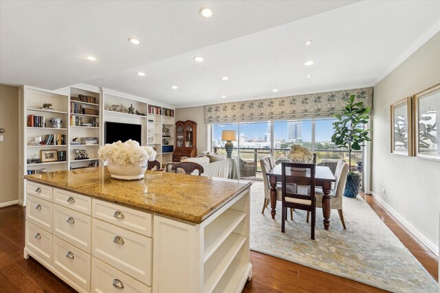 kitchen with a center island, open shelves, dark wood-type flooring, and light stone countertops