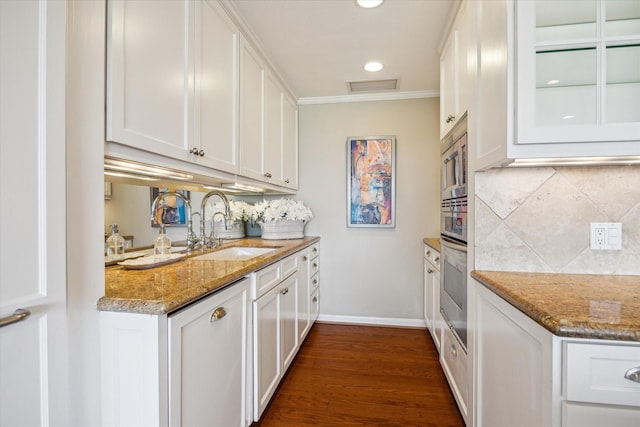 2929 Buffalo Speedway Unit A601, Houston, TX 77098 - kitchen featuring white cabinets, tasteful backsplash, dark wood-style flooring, light stone countertops, and crown molding