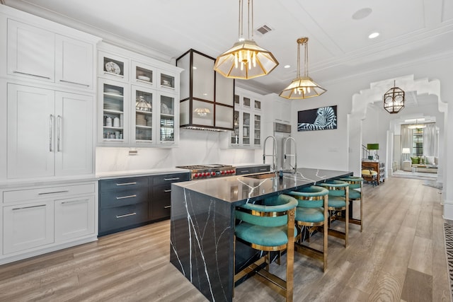 81 Crain Square Blvd, West University Place, TX 77025 - kitchen with a breakfast bar, a sink, white cabinetry, light wood-type flooring, and visible vents