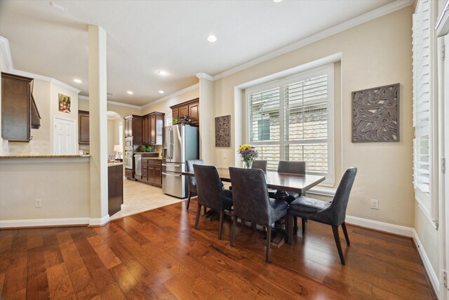 dining area with crown molding, recessed lighting, baseboards, and light wood-type flooring