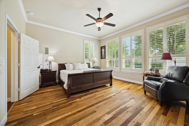 bedroom with baseboards, light wood finished floors, and crown molding