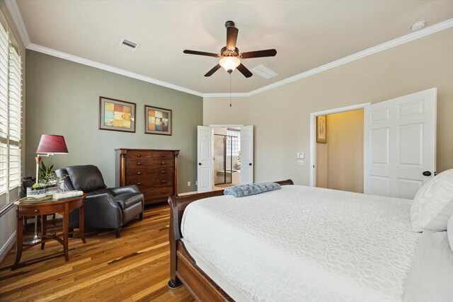 bedroom featuring ornamental molding, multiple windows, wood finished floors, and visible vents