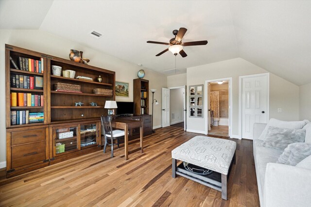 office area featuring ceiling fan, vaulted ceiling, wood finished floors, and visible vents