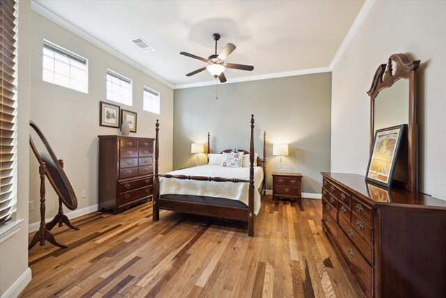 bedroom with crown molding, baseboards, visible vents, and light wood-style floors
