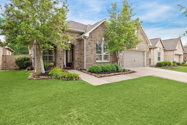 view of front of home featuring driveway, brick siding, fence, a front lawn, and a shingled roof