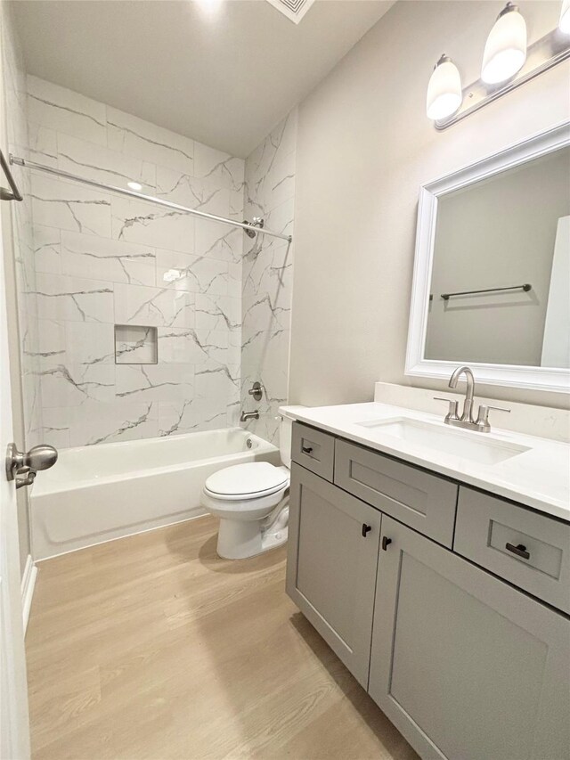 bathroom featuring bathing tub / shower combination, vanity, toilet, and wood finished floors