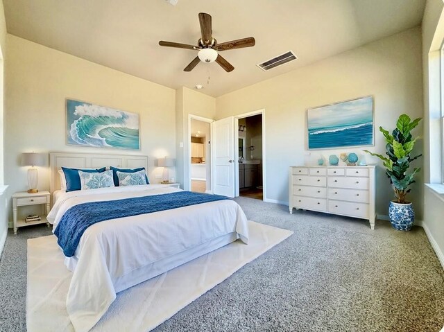 carpeted bedroom featuring ceiling fan, baseboards, visible vents, and ensuite bathroom