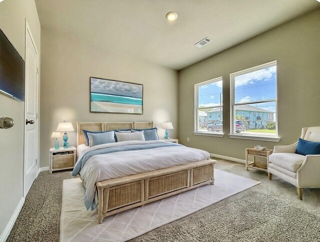 bedroom with baseboards, light carpet, and visible vents