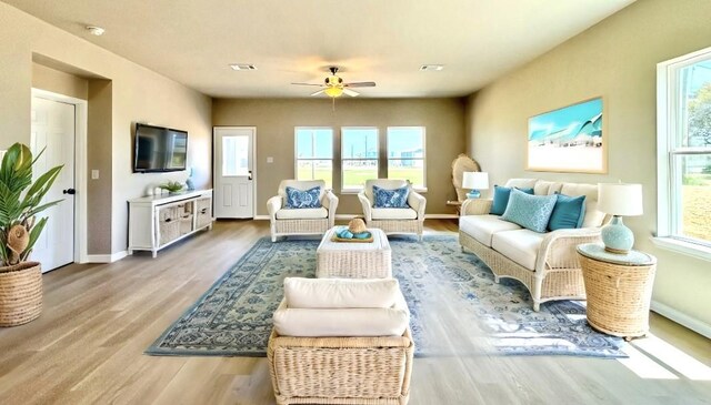 living room with baseboards, a ceiling fan, wood finished floors, and visible vents