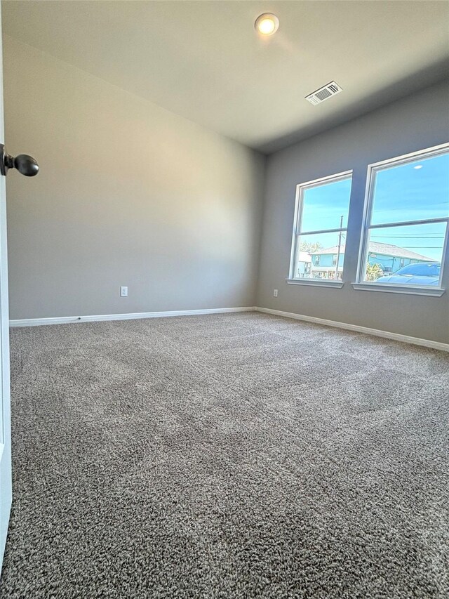 spare room with baseboards, carpet floors, and visible vents
