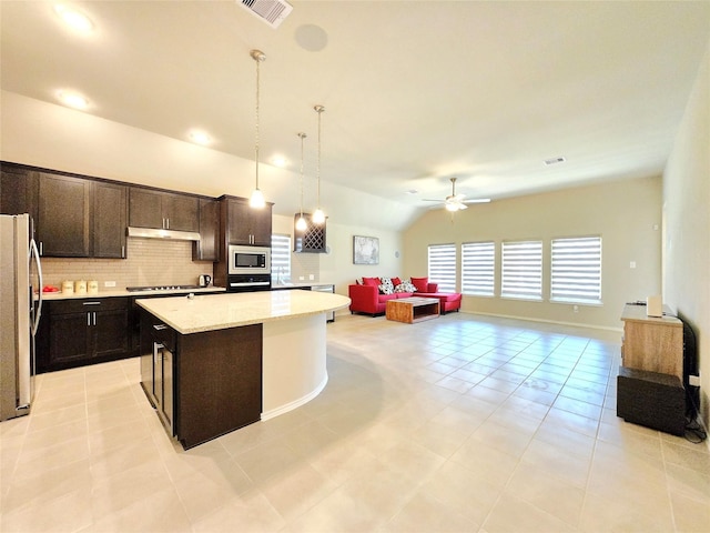 10422 Rigel Ridge Way, Richmond, TX 77406 - kitchen with appliances with stainless steel finishes, open floor plan, under cabinet range hood, a ceiling fan, and decorative backsplash