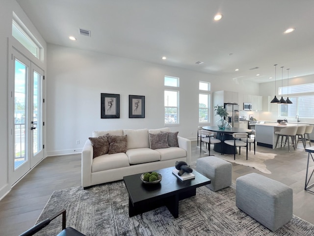 living room with visible vents, recessed lighting, and baseboards