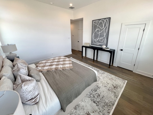 bedroom with baseboards, dark wood-style flooring, and visible vents