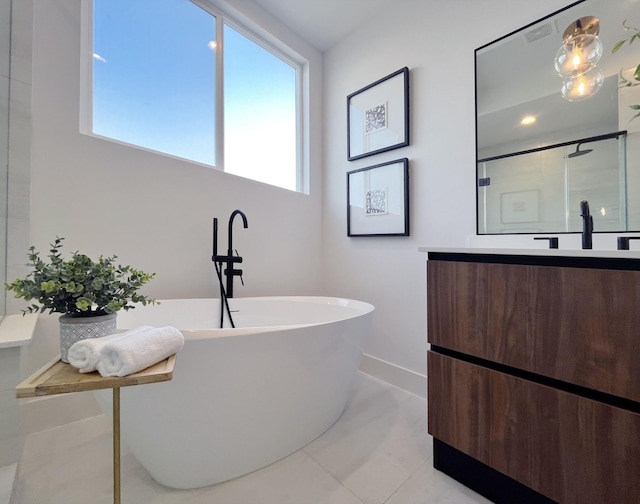 bathroom with tile patterned flooring, vanity, a shower, baseboards, and a soaking tub