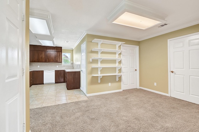 1004 8th St, San Leon, TX 77539 - kitchen featuring crown molding, dark brown cabinetry, visible vents, light countertops, and light carpet